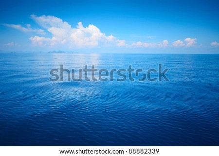 Tropical blue sea and blue sky with clouds. Mountains on the horizon