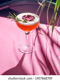 Tropical Cocktail On A Background Of Foliage, Shadows From The Sun. Pink Background