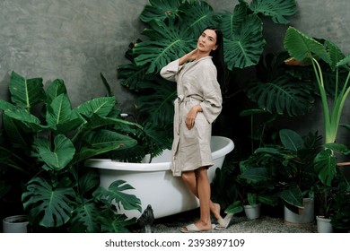 Tropical and exotic spa garden with bathtub in modern hotel or resort with young woman in bathrobe enjoying leisure and wellness lifestyle surrounded by lush greenery foliage background. Blithe - Shutterstock ID 2393897109