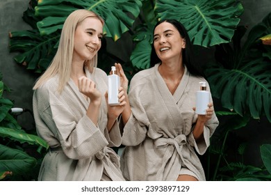 Tropical and exotic spa garden with bathtub in modern hotel or resort with two women in bathrobe holding beauty skincare product while enjoying leisure lush with greenery foliage background. Blithe - Shutterstock ID 2393897129
