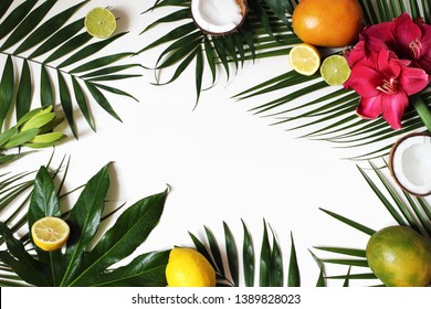 Tropical Floral And Exotic Fruit Frame, Web Banner. Coconut, Lemons, Mango And Amaryllis Flowers On Lush Plam And Aralia Leaves. White Table Background. Summer Vacation Concept. Flat Lay, Top View.