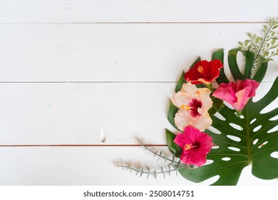 Tropical flowers and leaves on wooden background with copy space, summer vacational background - Powered by Shutterstock