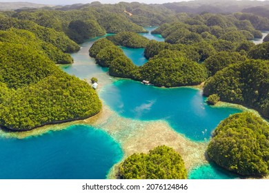 Tropical forest covered limestone around clear blue lagoons. Drone view of famous beautiful destination in Socorro Philippines, Sohoton Cove in Bucas Grande, Siargao. Best places in asia. - Powered by Shutterstock