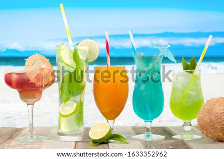 Tropical fresh drinks on sea background. Fresh mojito, juice and cocktails on the beach.