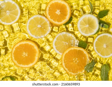 Tropical fruit pattern of orange, lime and lemon slices with ice cubes. Summer composition of fruits and vitamins. Summer vibes.