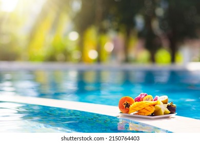 Tropical Fruit Plate At Swimming Pool. Mango, Pineapple, Orange And Fresh Juice On Summer Vacation At Exotic Island. Healthy Nutrition. Beach Holiday And Swim Fun.