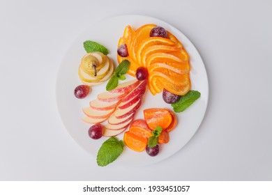 Tropical Fruit Salad On White Plate On White Background Photographed From Above.