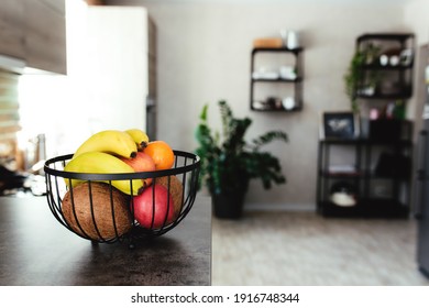 Tropical Fruits: Broken Coconut, Apple, Tangerine, Orange, Banana In Fruit Bowl On Bar Counter In Stylish Loft Kitchen. Blurred Background. High Quality Photo