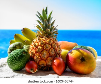 Tropical fruits collection, custard apple or green ripe cherymoia, passion fruit, pineapple, mango, tamarillo, avocado exotic fruits on blue sea background in sunny day - Powered by Shutterstock