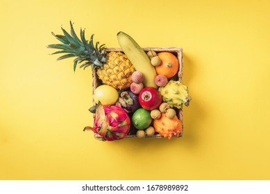 Tropical fruits on yellow background. Rattan box full of exotic thailand fruits - pineapple, pitahaya, kiwano, african horned melon, tamarillo fruit, granadilla, feijoa, salak, snake fruits, maracuya - Shutterstock ID 1678989892