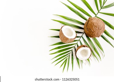 Tropical Green Palm Leaf, Cracked Coconut On White Background.  Nature Concept. Flat Lay, Top View