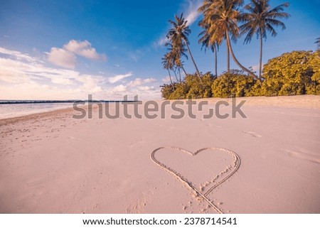 Tropical island beach with heart shape in sand. Idyllic romantic love and honeymoon proposal summer travel vacation background concept. Amazing nature romance and couple symbol defocus palm trees sky