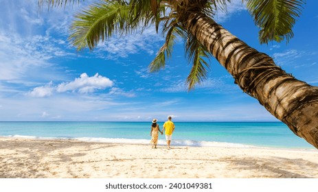 Tropical Island Koh Kood or Koh Kut Thailand Men and women on vacation walking under a palm tree at a white beach at Koh Kut Island Thailand - Powered by Shutterstock