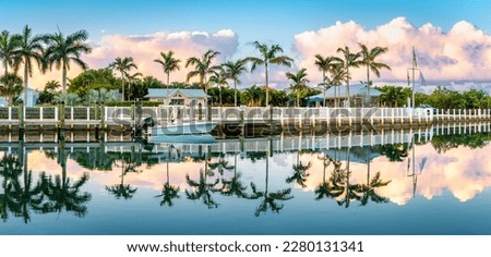 Tropical landscape with palm trees reflected in a canal at sunrise, in Key West, Florida.