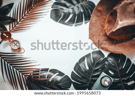 Tropical leaves, ala Indiana Jones hat, Travel adventure concept Blank white background, surreal color 