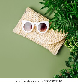 Tropical Leaves And Beach Bag With Sunglasses  On  Green  Background. Top View, Flat Lay.