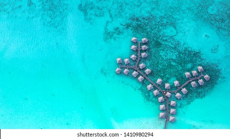 Tropical paradise aerial view of overwater bungalows in the middle of blue lagoon with corals. Luxury travel vacation destination, Bora Bora, Society Islands, Tahiti, French Polynesia