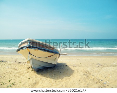 Tropical Seascape with a fishing boat on beach on warm sunset, Sri Lanka.Beach Sri lanka.Sun and Sand