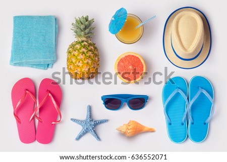 Tropical summer vacation concept with pineapple, juice and flip flops organized on white background. View from above. Flat lay