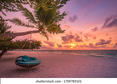 Tropical sunset beach and sky background as exotic summer landscape with beach swing or hammock and white sand and calm sea beach banner. Paradise island beach vacation or summer holiday destination