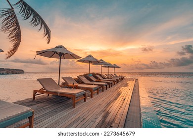 Tropical sunset over outdoor infinity pool in summer seaside resort, beach landscape. Luxury tranquil beach holiday, poolside reflection, relaxing chaise lounge romantic colorful sky, chairs umbrella
 - Shutterstock ID 2273645679