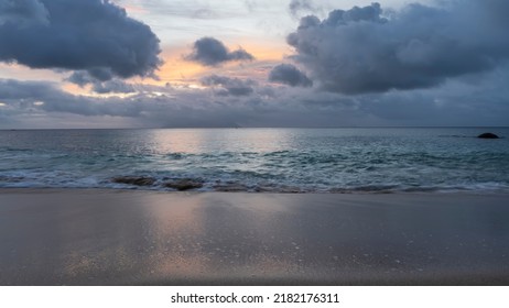 Tropical sunset. The sky between dark blue clouds is highlighted yellow, pink. Reflection on the surface of the ocean and the wet sand of the beach. Seychelles. Mahe. Beau Vallon - Shutterstock ID 2182176311