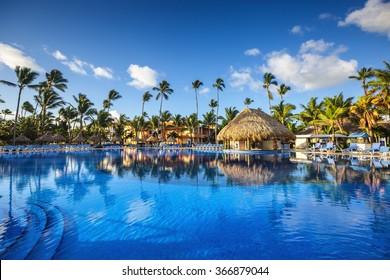 Tropical swimming pool and palm trees in luxury resort
