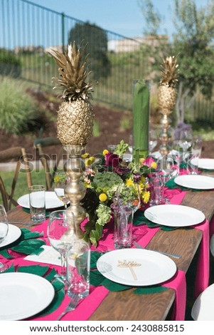 Tropical Theme Table Setting with Gold Pineapples and Flowers