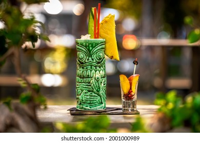 Tropical tiki cocktail on the bar with fruits.