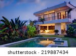 Tropical villa view with garden, swimming pool and open living room at sunset