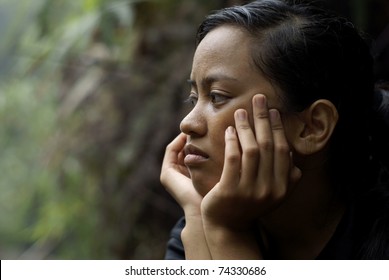 Troubled Asian Teen Girl Thinking With Hands On Face