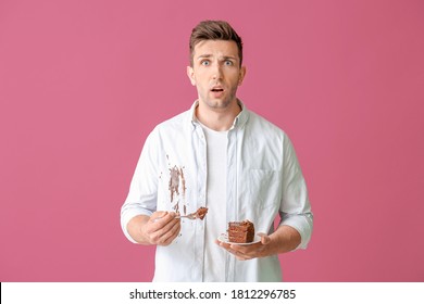 Troubled Man In Dirty Clothes Eating Chocolate Cake On Color Background