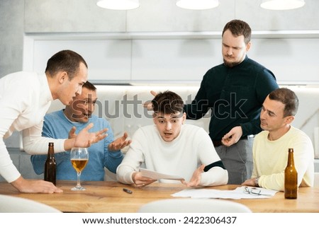 Troubled man reading legal notice surrounded by friends providing moral support sitting at table n home kitchen during informal friendly meeting.. Foto stock © 