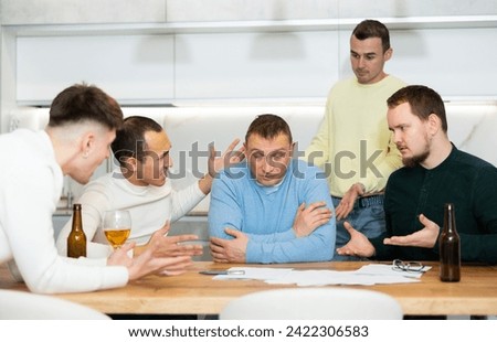 Troubled man reading legal notice surrounded by friends providing moral support sitting at table n home kitchen during informal friendly meeting.. Foto stock © 