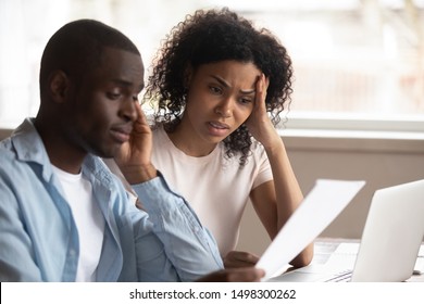 Troubled Pensive Biracial Young Couple Feel Disappointed Consider Paperwork Paying Bills Online, Sad Frustrated Mixed Race Ethnicity Family Upset Having Financial Problems, Stressed About Bankruptcy