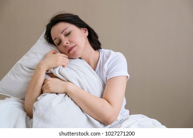 Troubled Woman In Bed Covering Ears To Shut Out Noise. Daytime Sleep Concept. Drowsiness And Nap Concept. Close Up. Exhausted Mother Dozing After Sleepless Night, Feeling Lack Of Sleep, Stress Relief