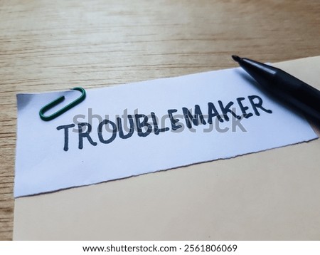Troublemaker writting on table background.