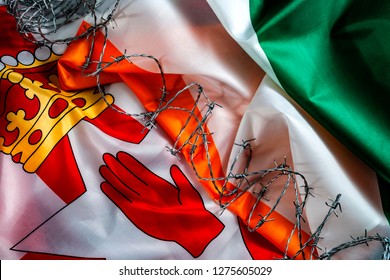 The Troubles, Good Friday Agreement And Hard Border Between Northern Ireland And The Republic As A Result Of Brexit Concept With The Flags Of Of Both Irish Countries Separated By Barbwire
