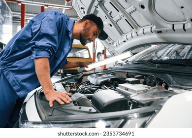 Troubleshooting process. Auto mechanic working in garage. Repair service. - Powered by Shutterstock