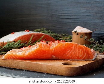 Trout Filet On A Wooden Board, Coarse Salt, Fresh Rosemary, Thyme Sprigs. Black Wooden Background