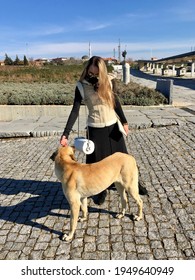 Troy, Turkey - March 2021 A Young Woman With A Dog On The Background Of A Spring Landscape In Troy 