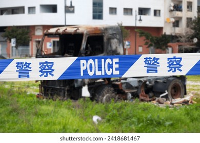 Truck burnt by a pyromaniac with a police tape with written in it in Chinese 