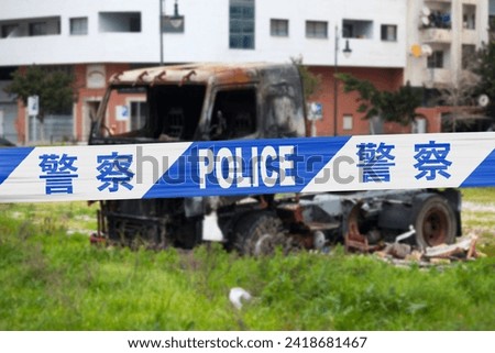 Truck burnt by a pyromaniac with a police tape with written in it in Chinese '警察 - POLICE - 警察'. 商業照片 © 