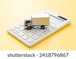 Truck and calculator on a yellow background.