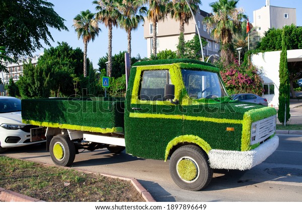 truck car decorated\
artificial green grass. Concept of energy saving, Sustainable\
transport, save ecology.