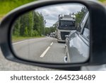Truck and Car Traffic Seen in Rearview Mirror – Highway Transportation and Driving Concept with Vehicles in Line on Country Road