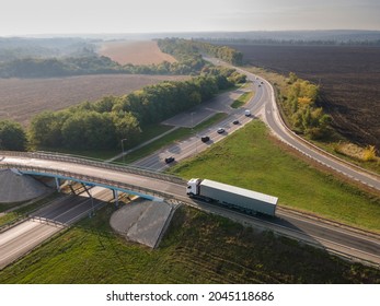 Truck With Cargo Semi Trailer Moving On Road In Direction. Highway Intersection Junction. Aerial Top View