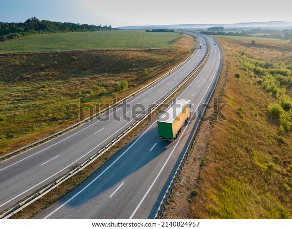 Truck with Cargo Semi Trailer Moving on\
Summer Road. Aerial Top View. White\
vehicle
