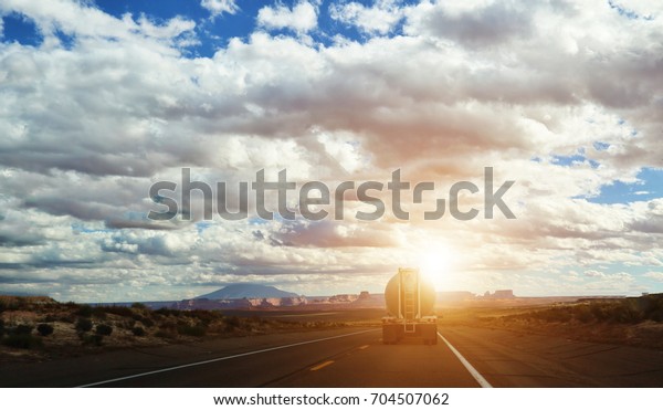Truck carrying\
a cargo at sunset on USA\
highway