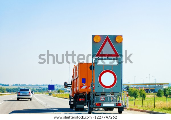 Truck carrying empty triangle and\
empty circle traffic road sign in highway in\
Poland.